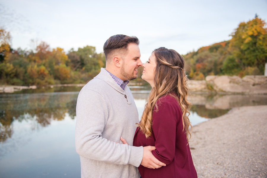 a couple kisses by the river during their engagement session with toronto wedding photographer life is beautiful photography