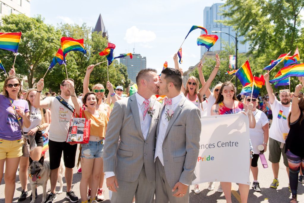 after their gay wedding, newlyweds kiss in the middle of the london pride festival parade