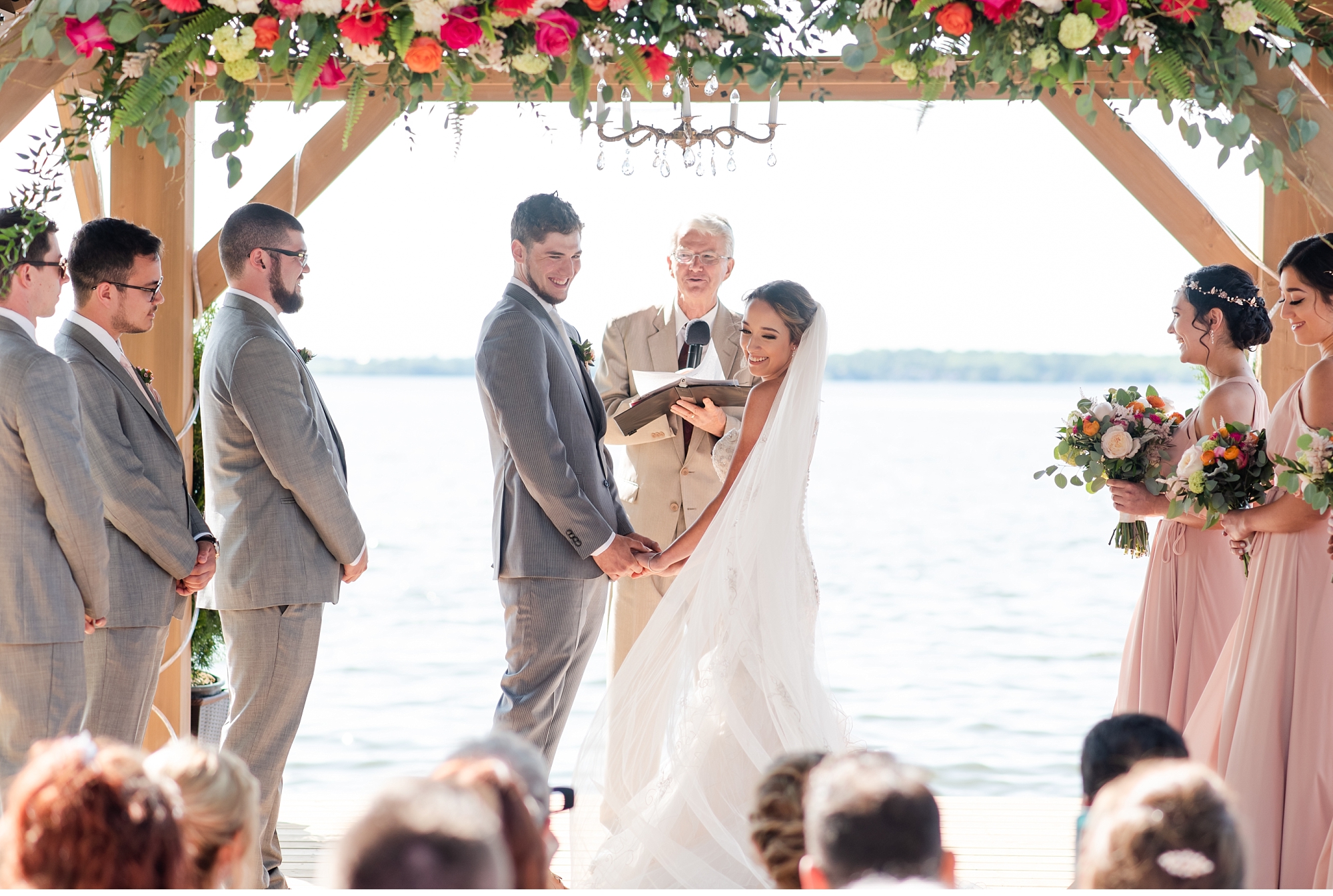 bride and groom hold hands and look at their guests at kawartha lakes wedding
