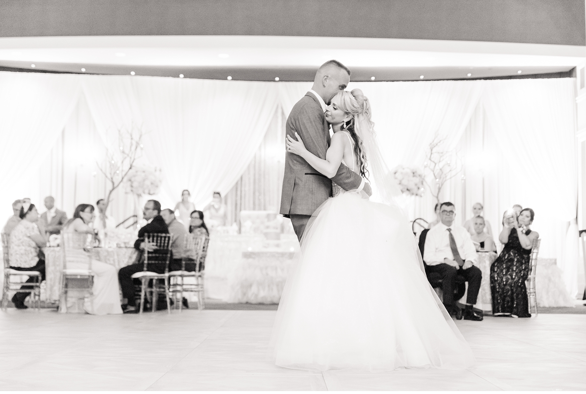 a bride and groom dance together for their first dance during their wedding at best western lamplighter inn
