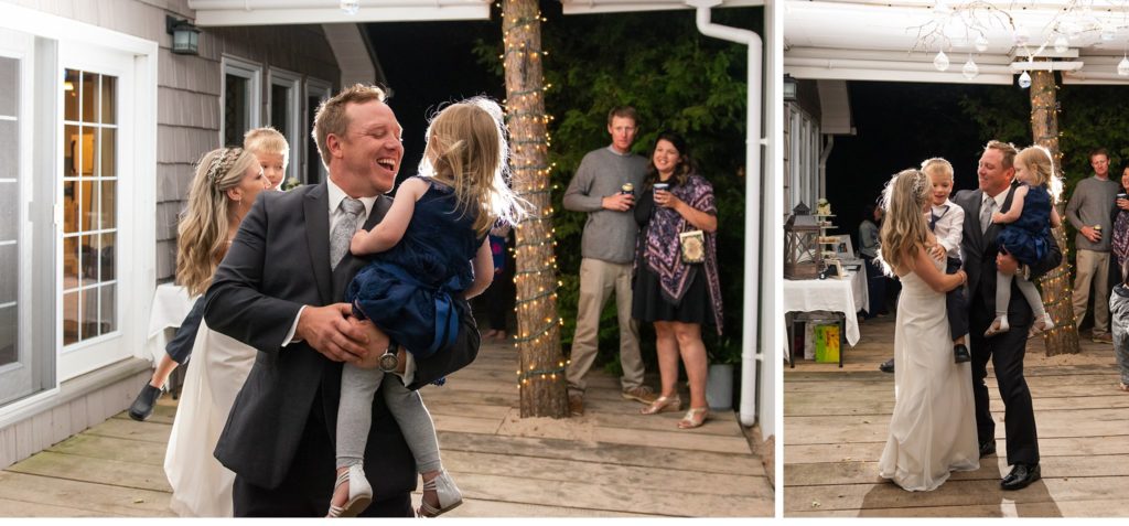 a bride and groom dance together while holding their kids at their Grand Bend wedding