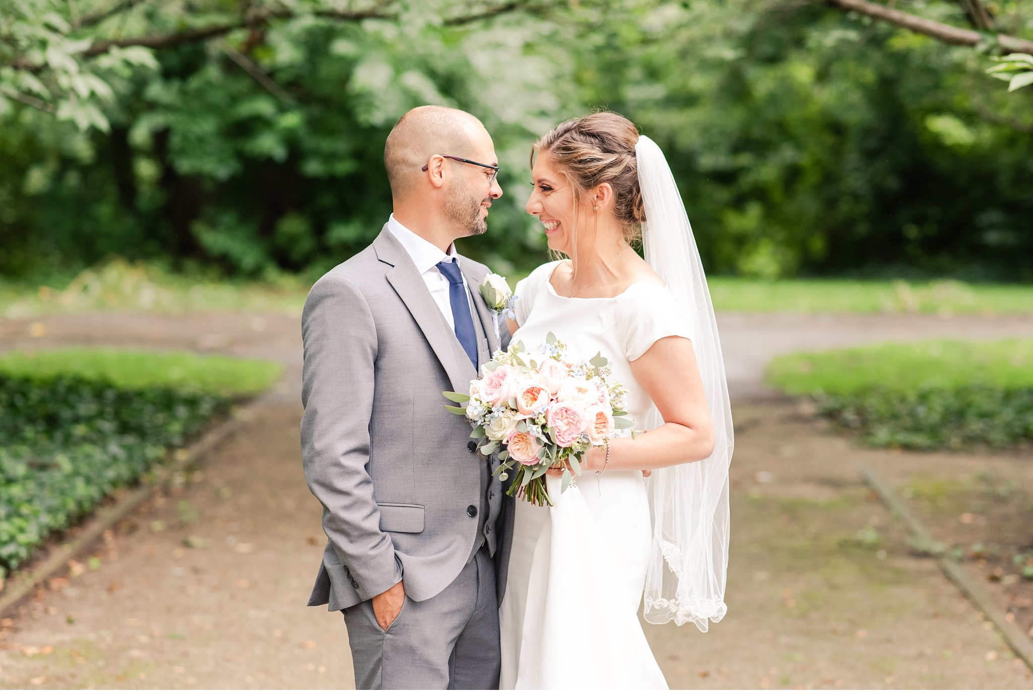 bride and groom smiling at each other on a path at their wedding in london ontario