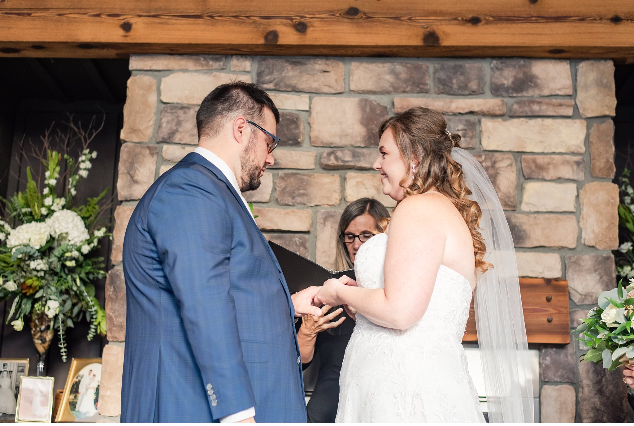 bride places ring on groom's finger during their wedding ceremony
