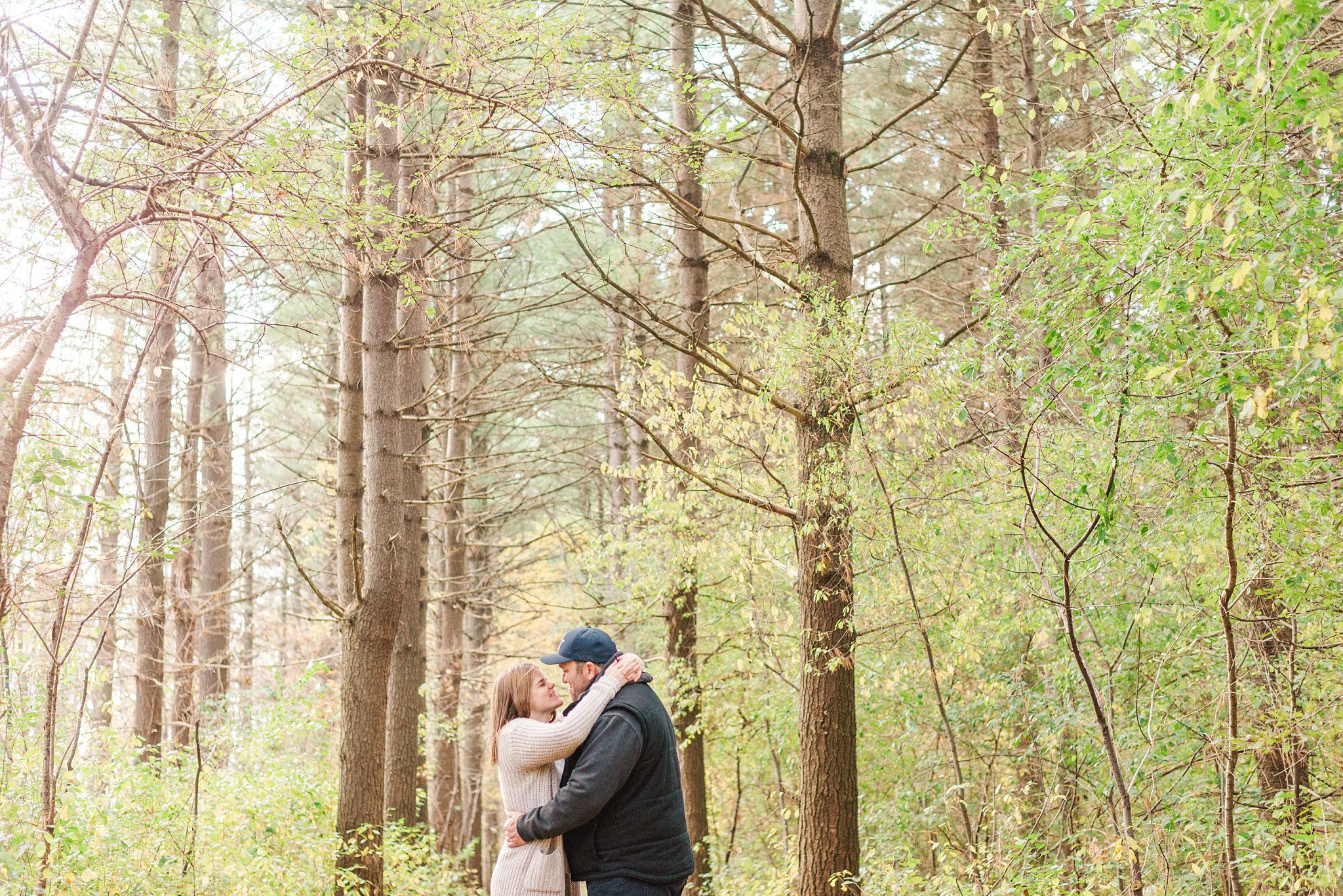 fall engagement photo of a couple hugging at fanshawe conservation area