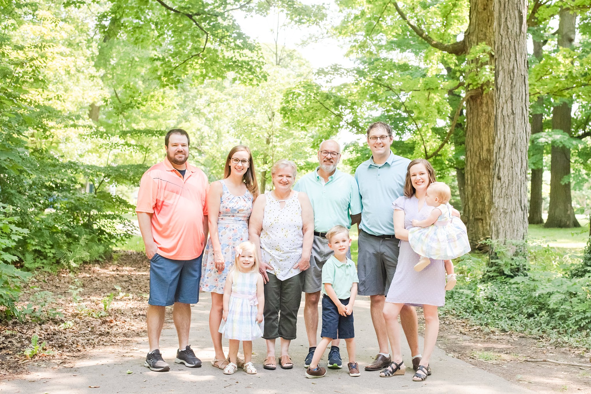 family photos in springbank park; grandparents with kids and grandkids on a tree-lined path