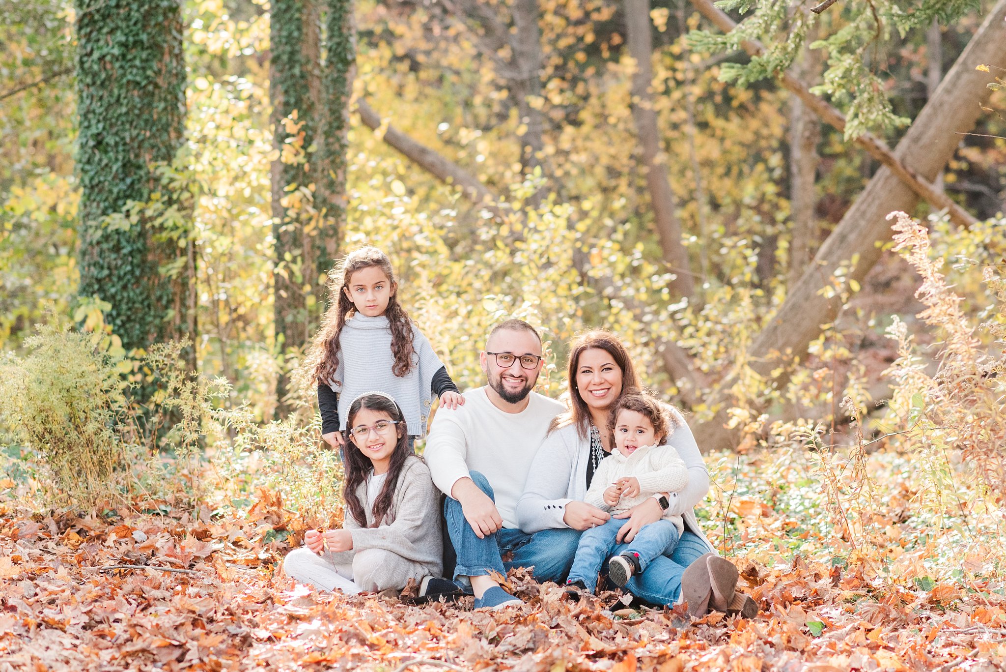 family photos in springbank park; family sits together in the fall leaves