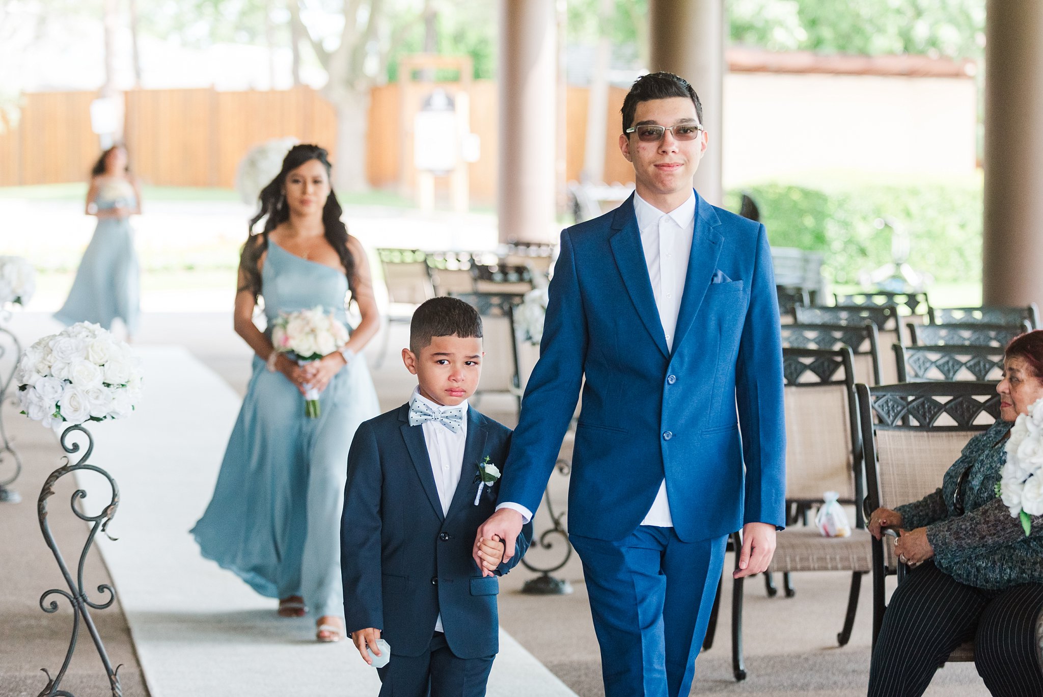 a bridesmaid and ring bearer walk down the aisle