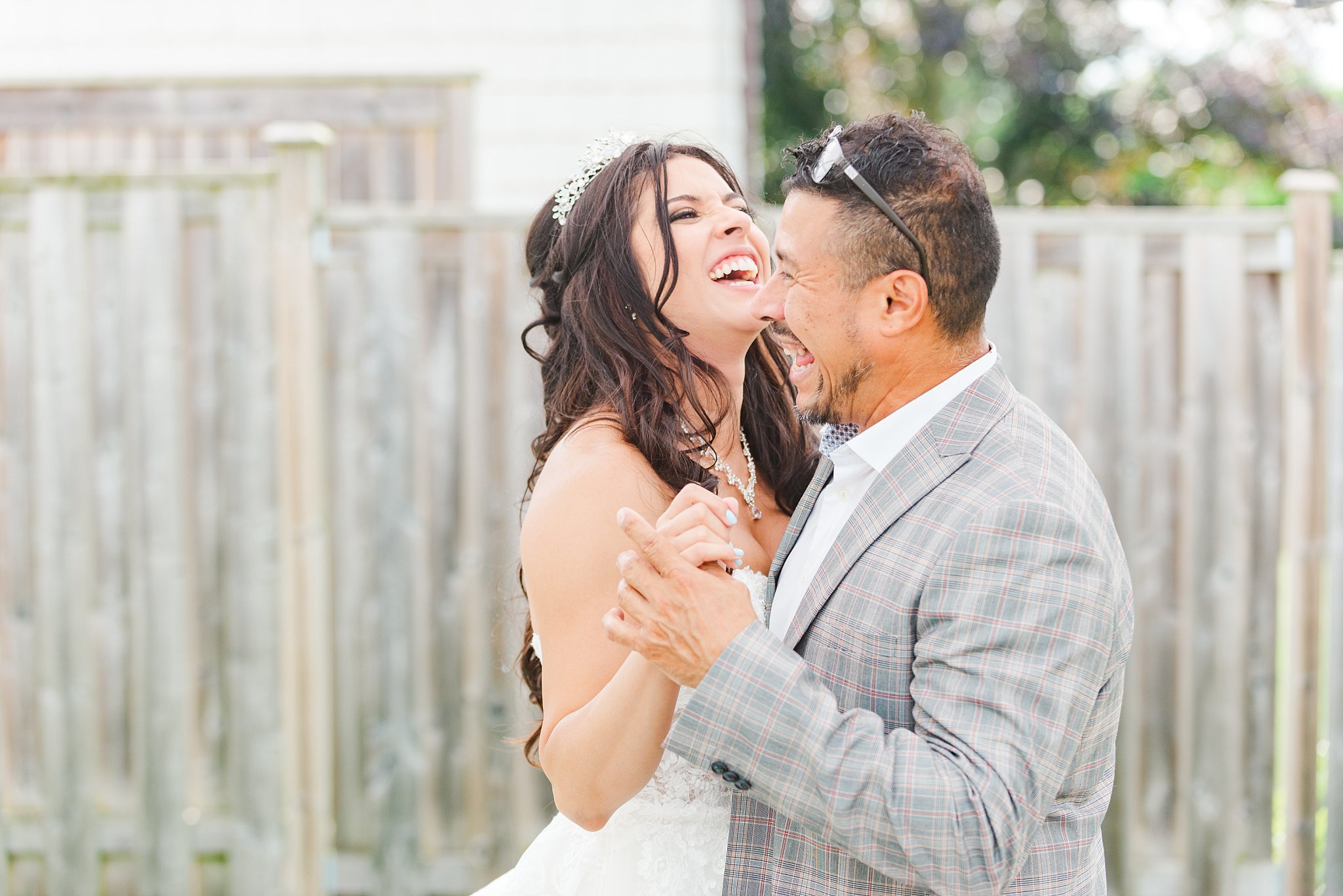 a bride laughs with her dad during their father daughter dance  kelowna wedding photographer