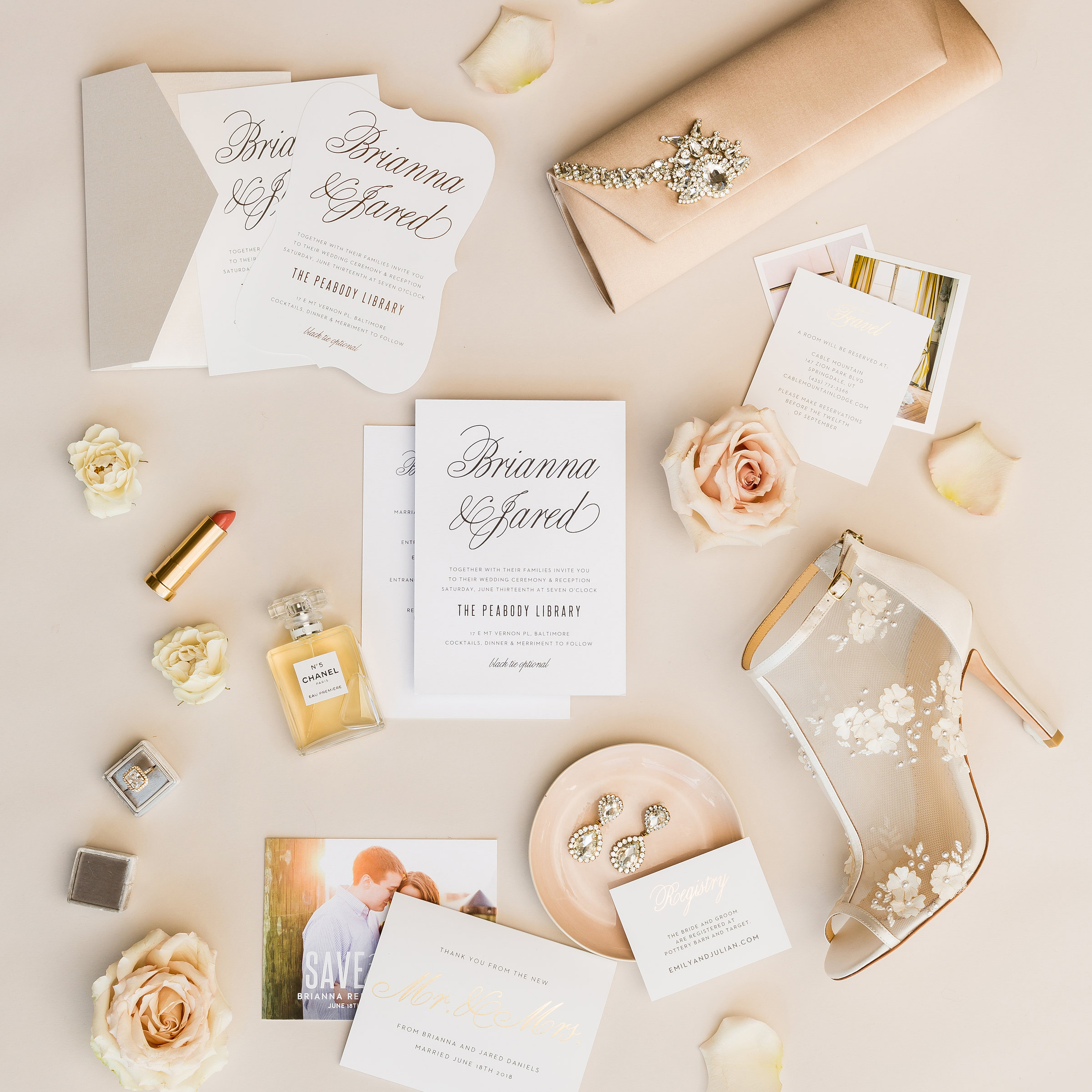 wedding invitations laying on a pink background, surrounded by bridal accessories. basic invite online wedding invitation, toronto wedding photographer