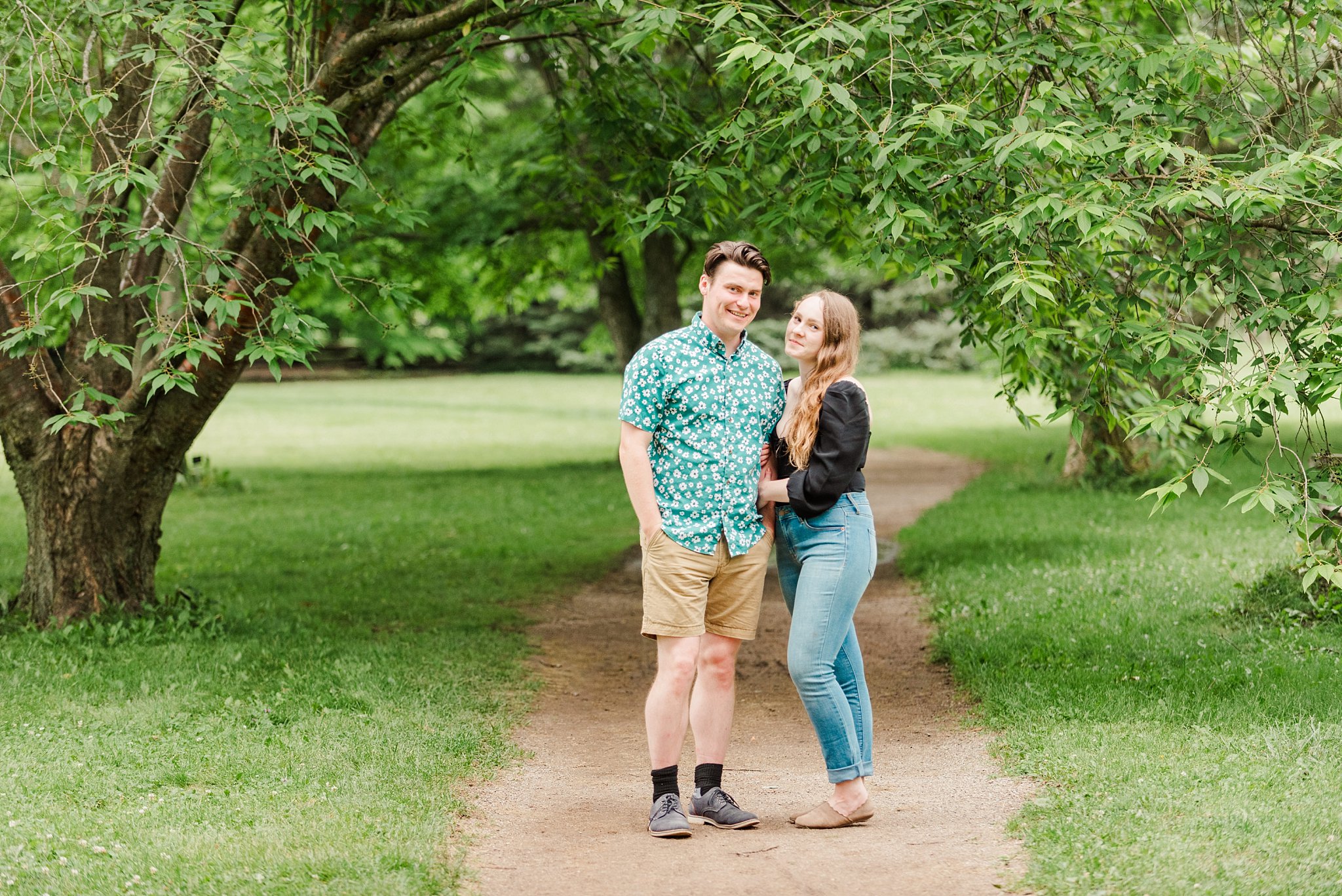 a couple stands together on a path at guelph arboretum
