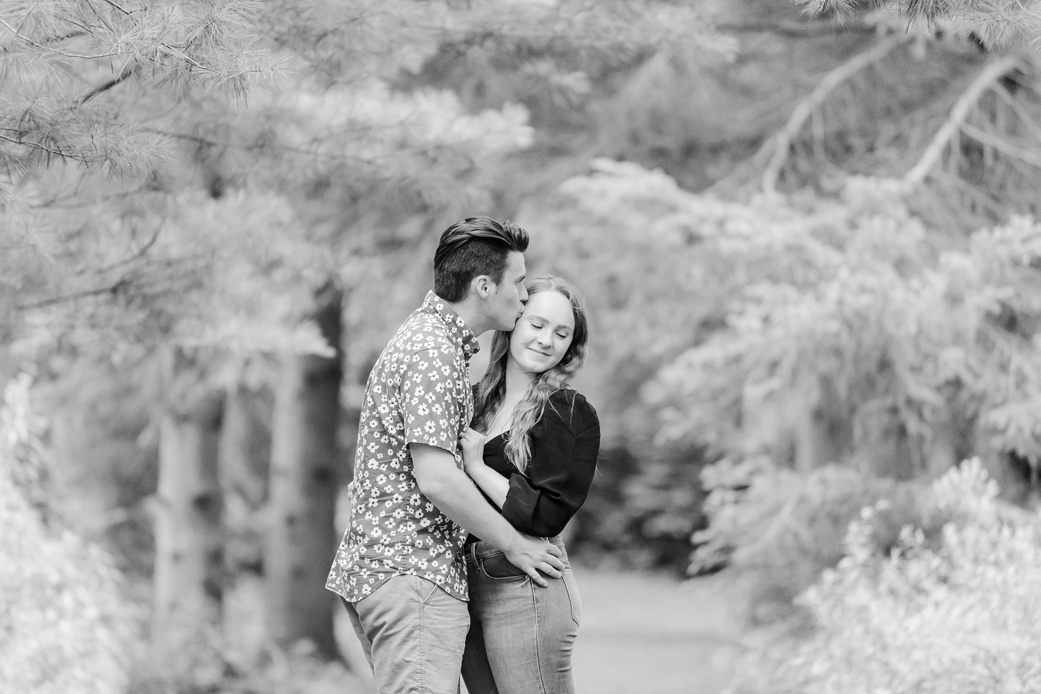a man kisses a woman's forehead - black and white photo by guelph arboretum wedding photographer life is beautiful photography