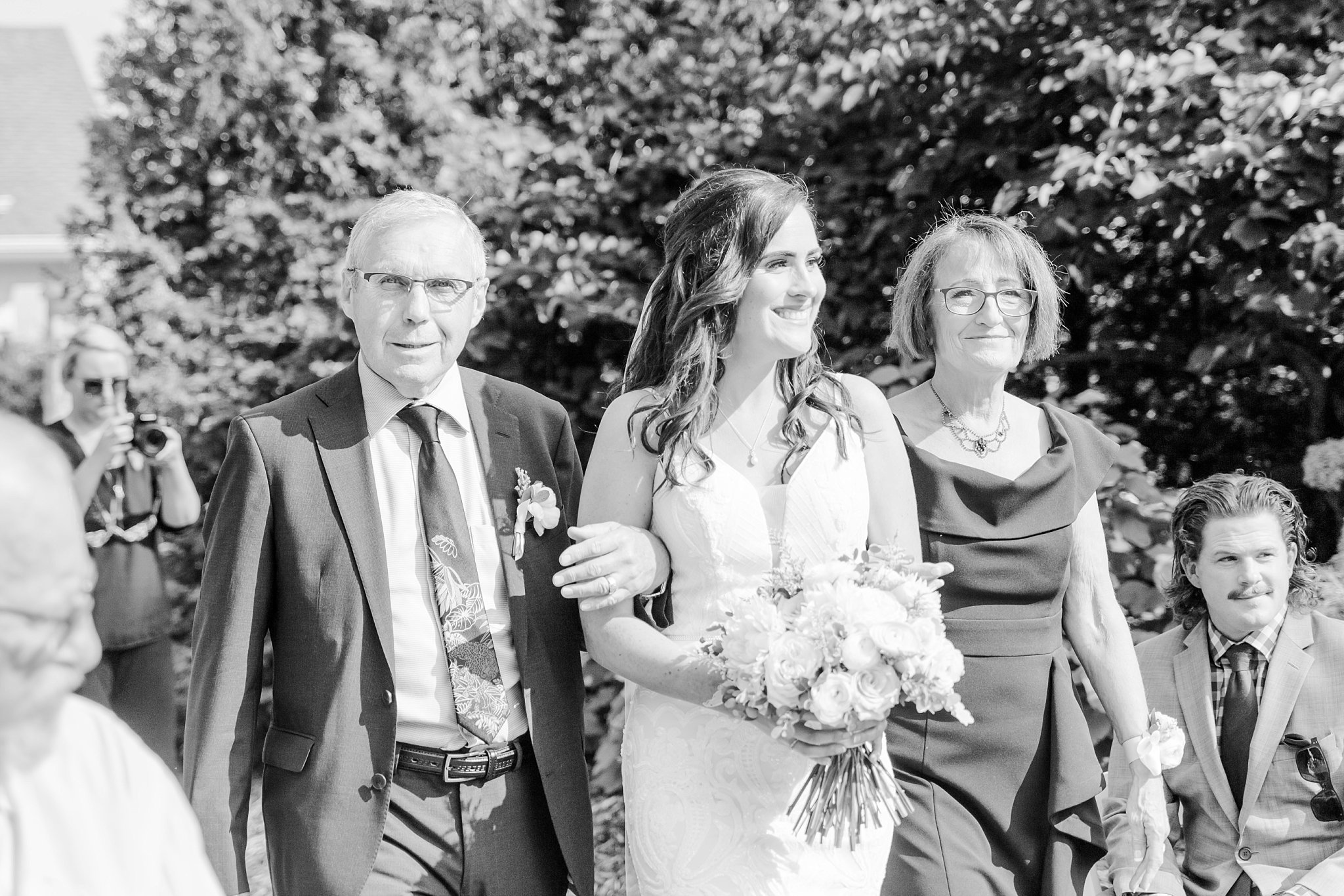 a bride walks down the aisle with her parents