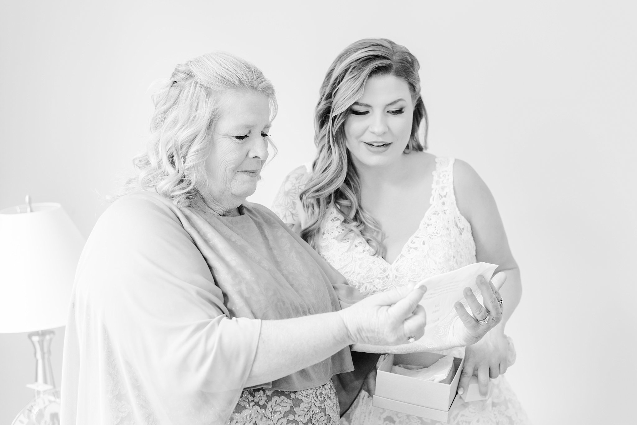 a bride reads a message to her mom written on a handkerchief during her wedding at fernwood hills