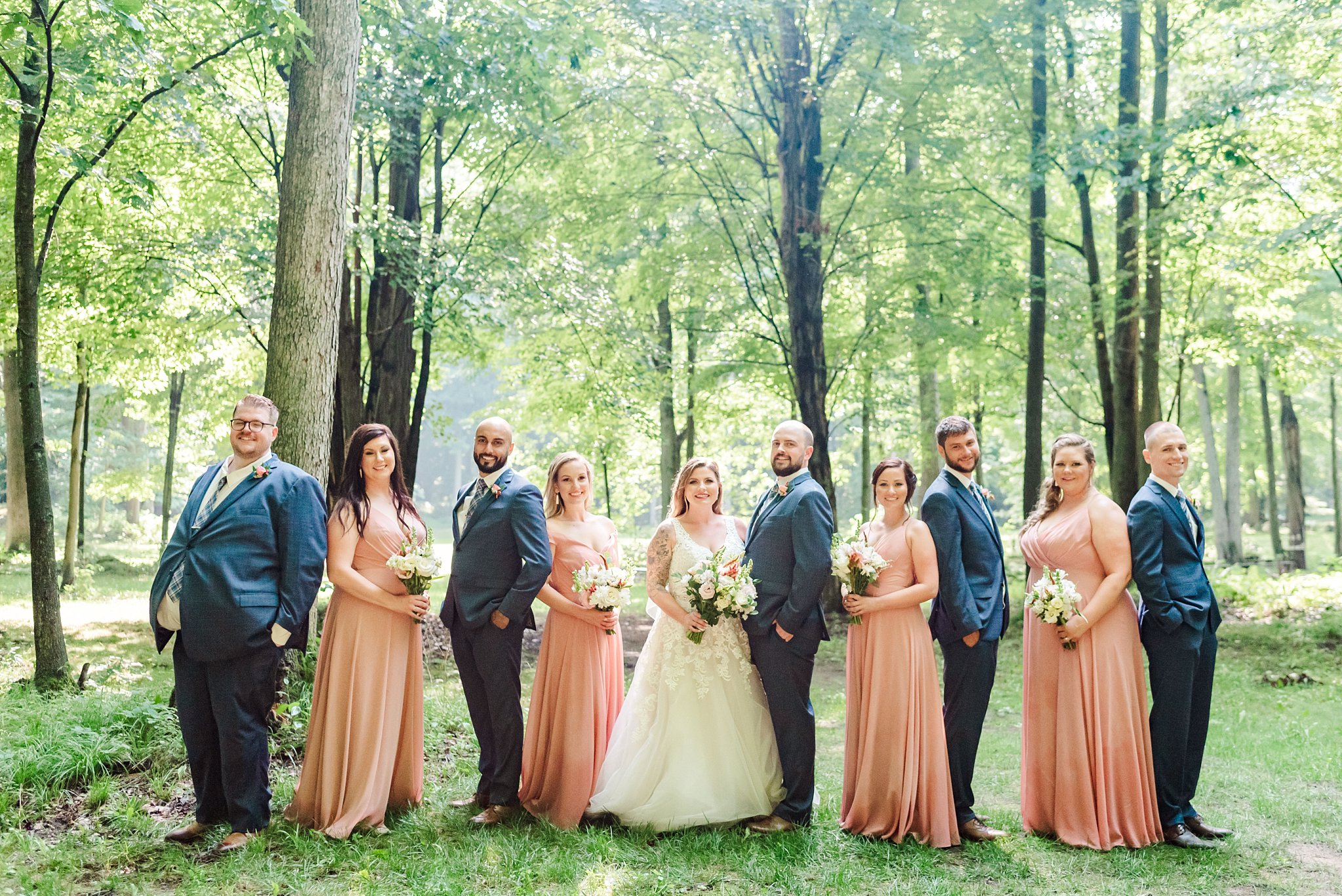 a wedding party poses in a forest at fernwood hills
