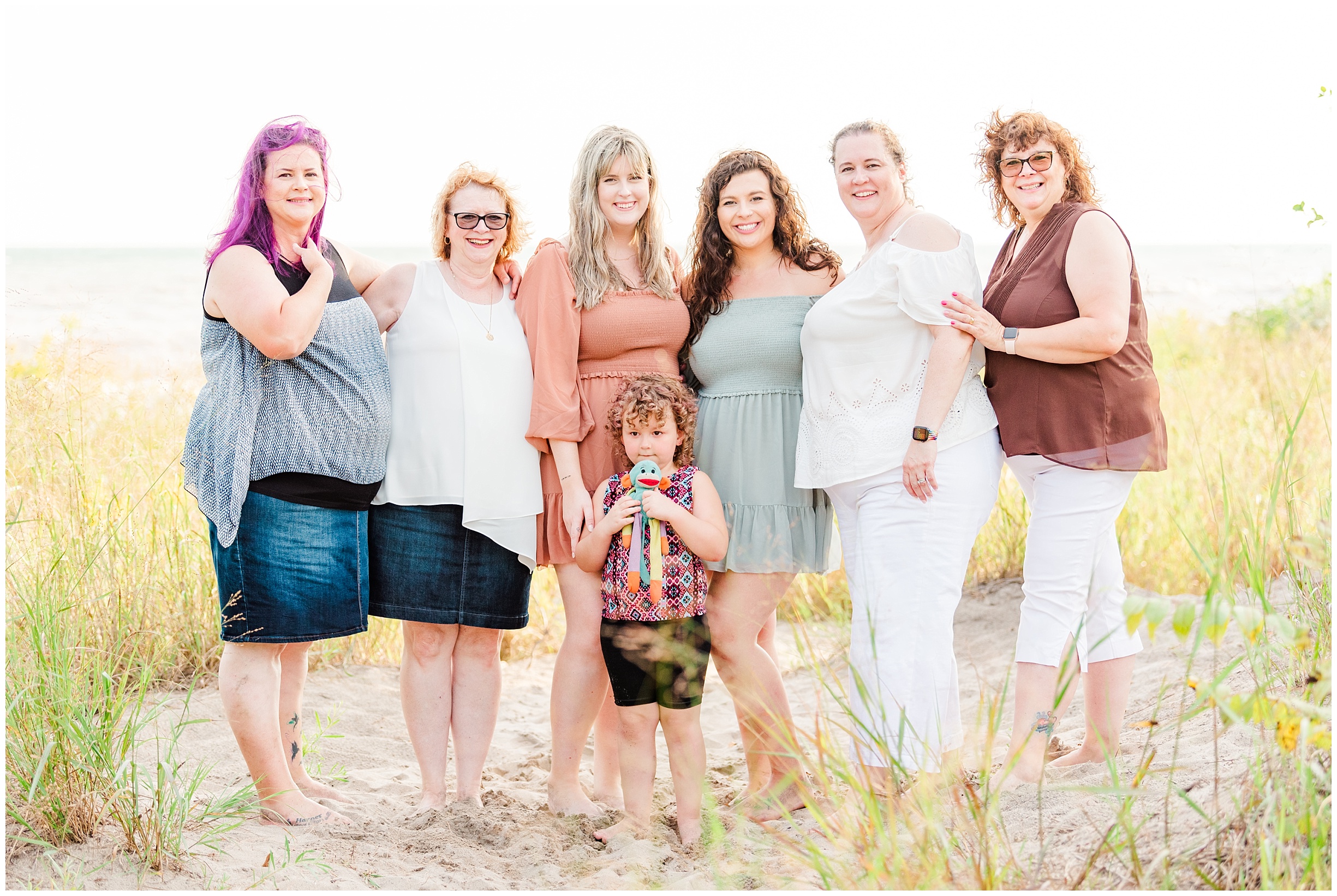 a grandmother poses with her daughters, daughter in law, and granddaughters