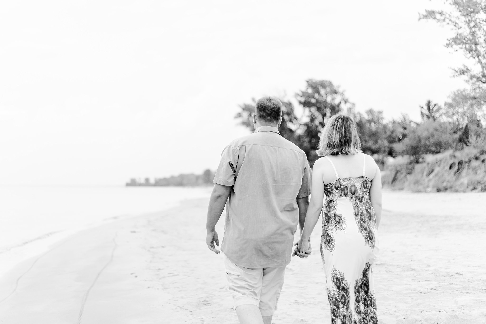 a black and white photo of a couple walking away down the beach. grand bend weddings