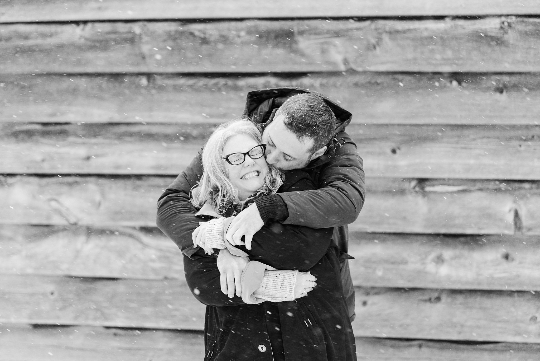 a man hugs and kisses his fiance by london ontario weddings photographer life is beautiful photographhy