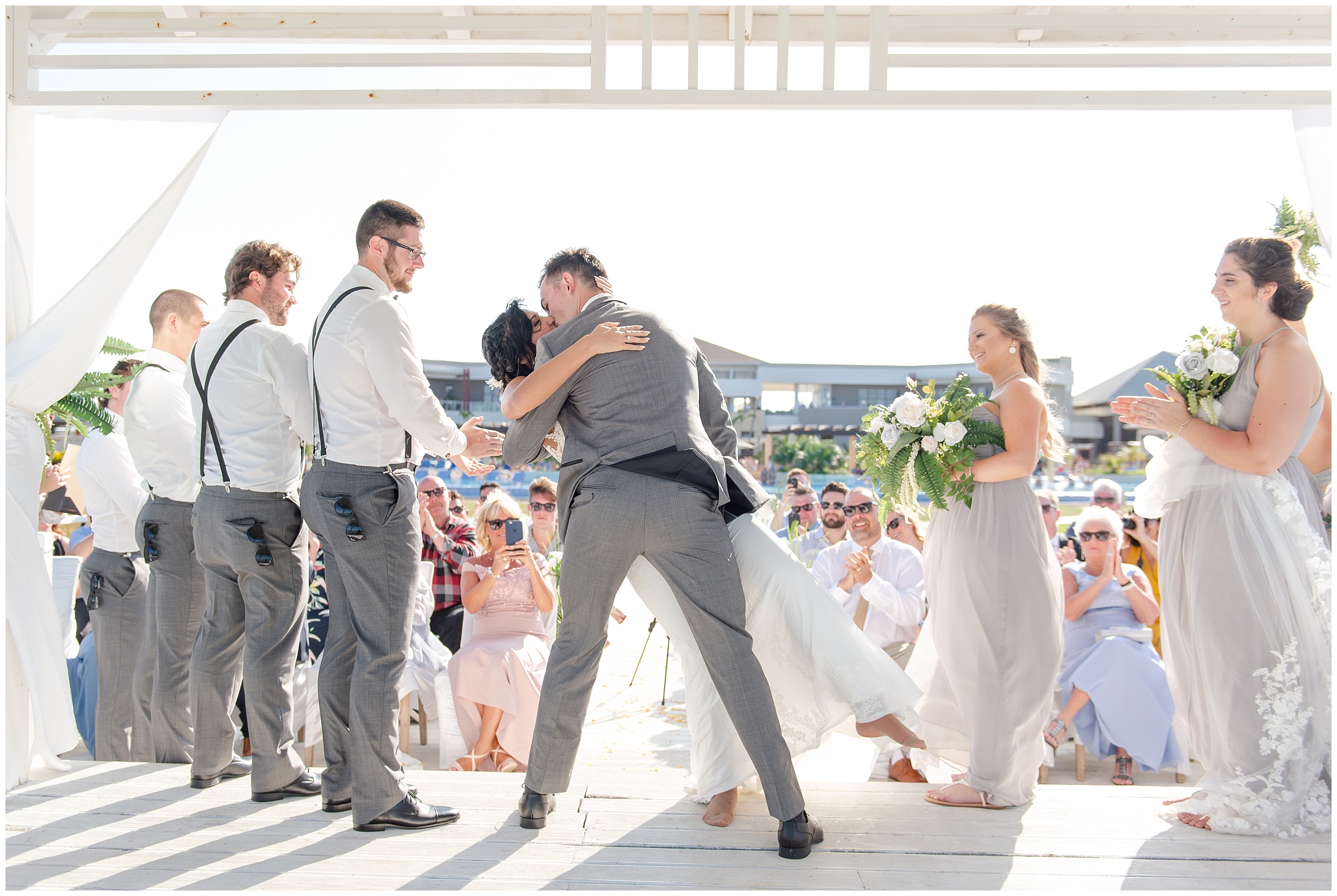 a groom dips his bride during their destination wedding at pullman cayo coco, used in a blog post about how much does a wedding photographer cost?
