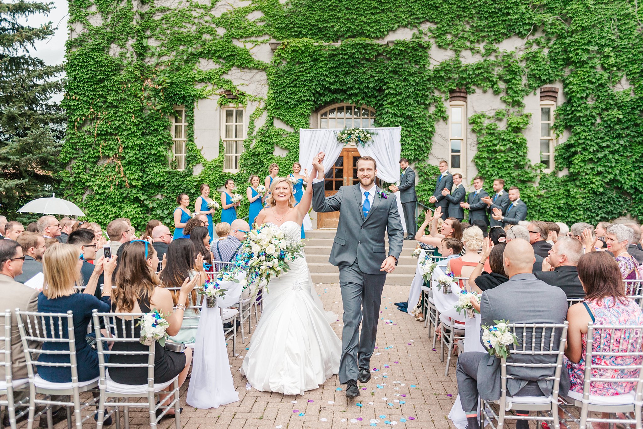 a bride and groom throw their arms in the air as they walk down the aisle after their wedding ceremony at the old courthouse in london ontario. tips for wedding photographers by life is beautiful photography