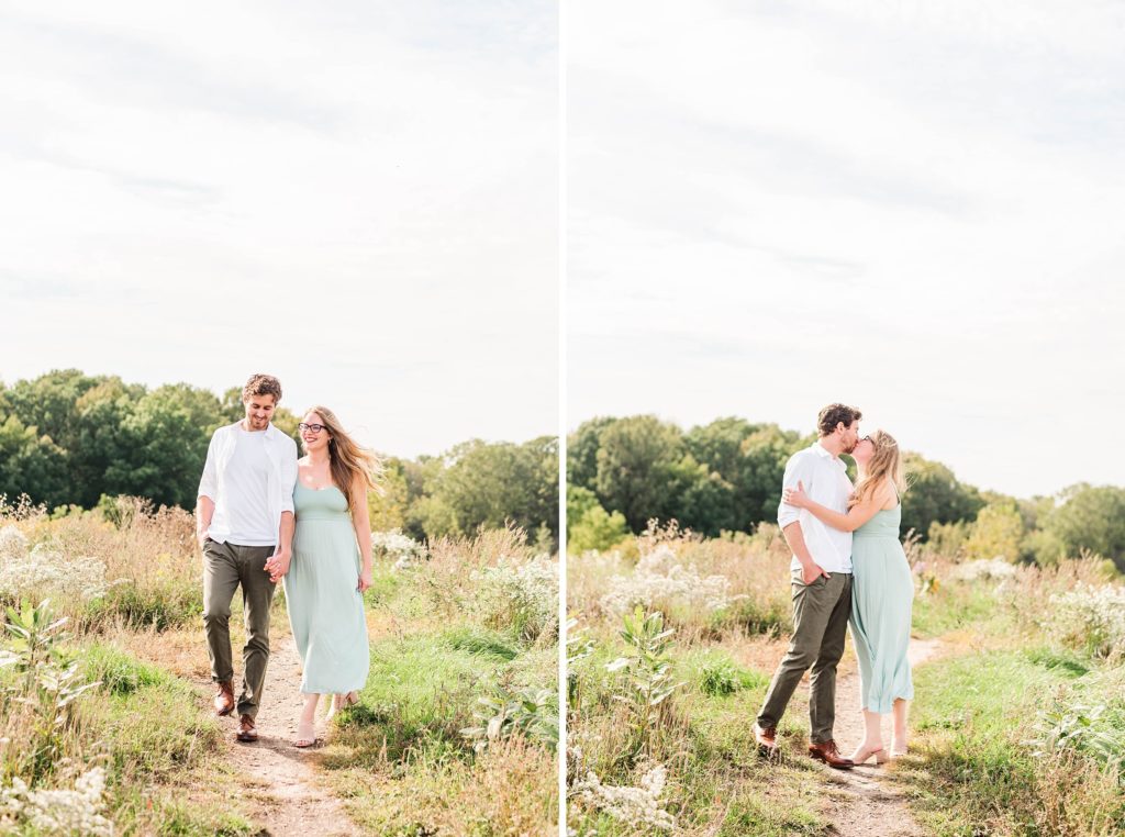 a man and woman hold hands and walk down a hill in euston park. london ontario engagement photographer