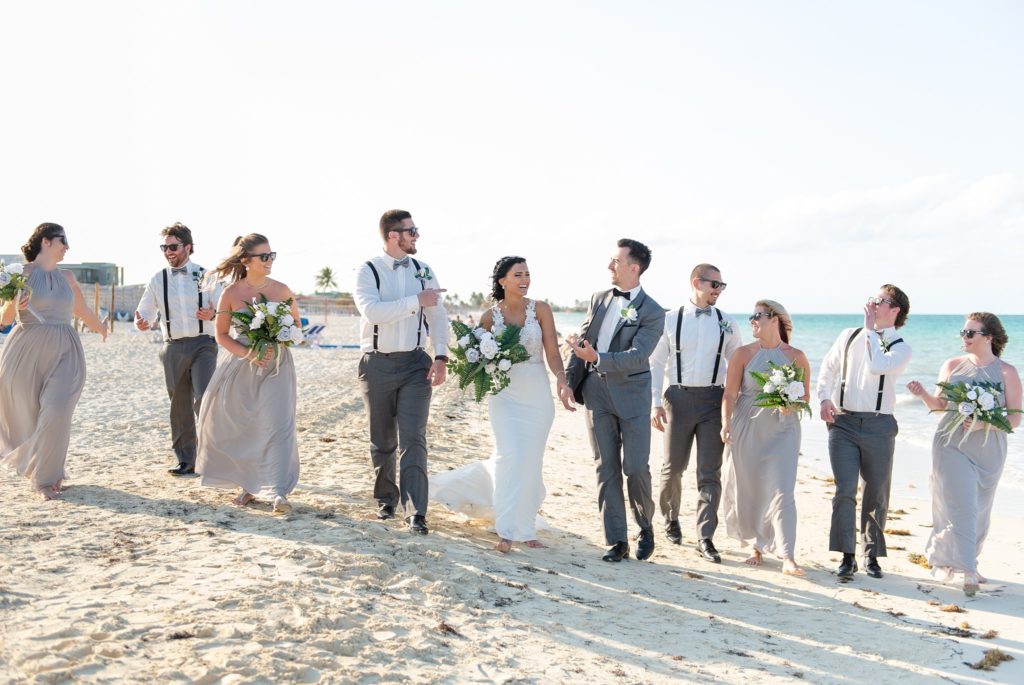 a wedding party walks down the beach during a destination wedding in cayo coco cuba