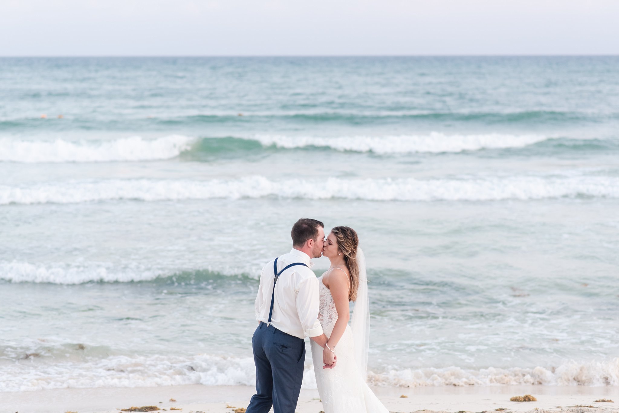 a couple kisses on the beach in cancun mexico by destination wedding photographer life is beautiful photography