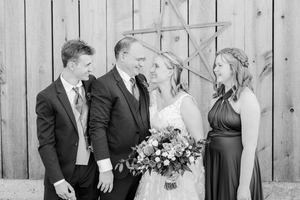 a black and white photo of a wedding party laughing