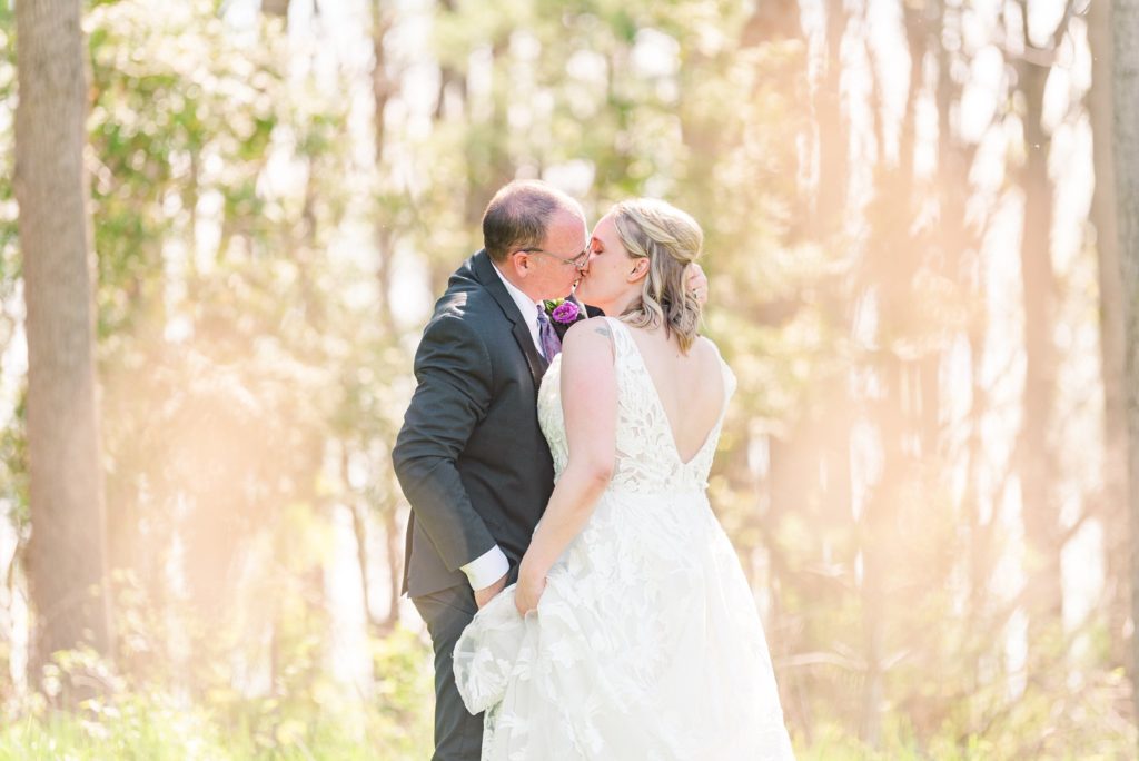 a bride and groom kiss in a forest