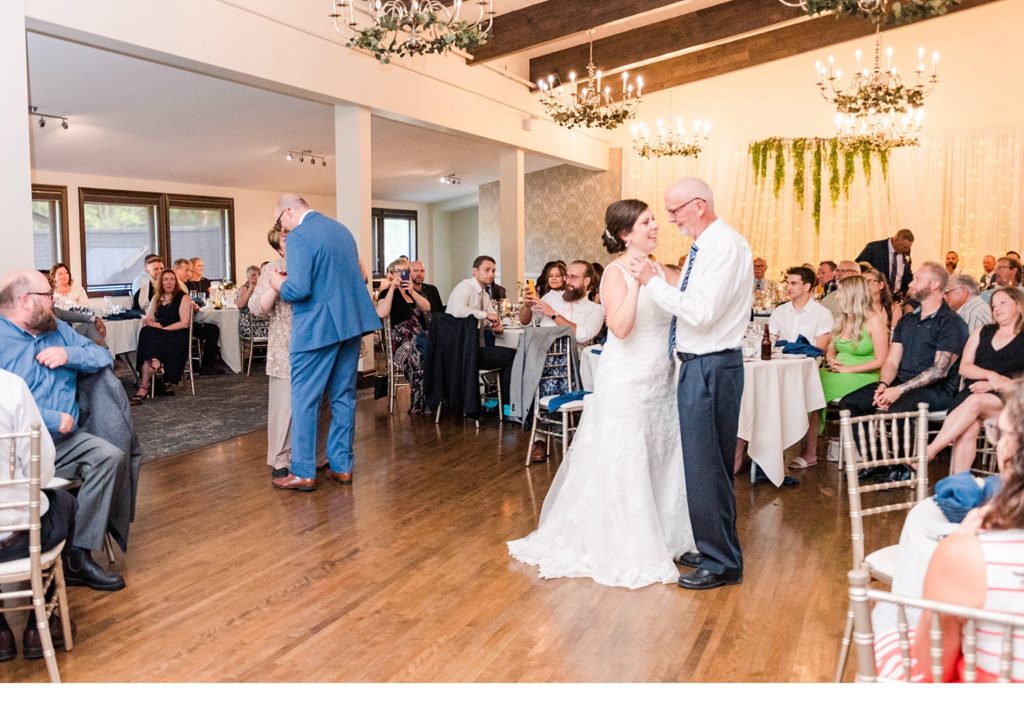 a bride dances with her dad and a groom dances with his mom while their wedding guests look on at stratford country club