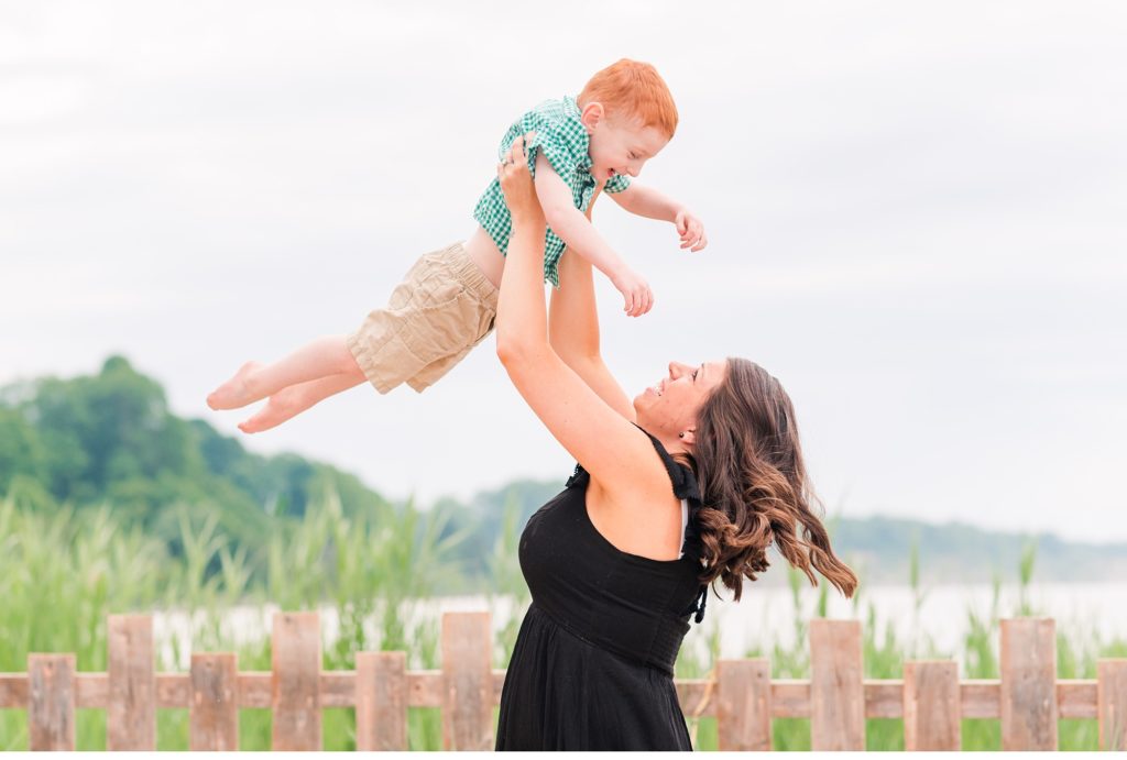 a mom lifts her son in the air. family photography london ontario