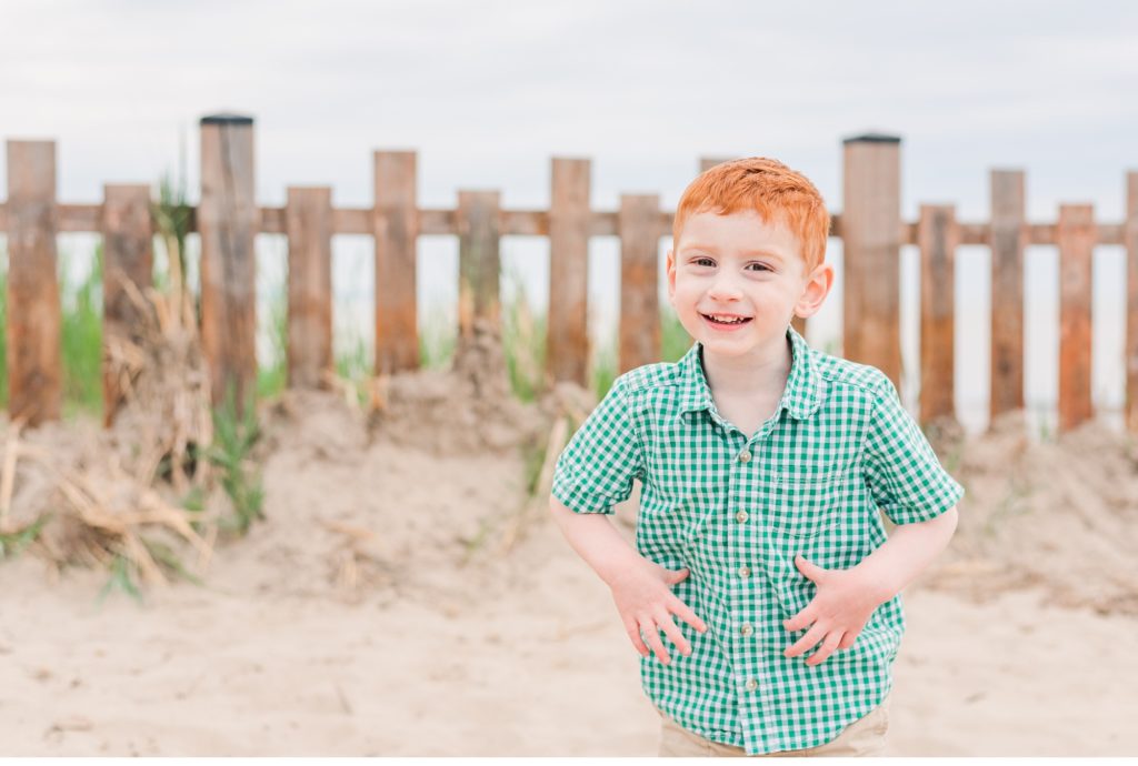 a little boy laughs at the camera during a family photo session in port burwell